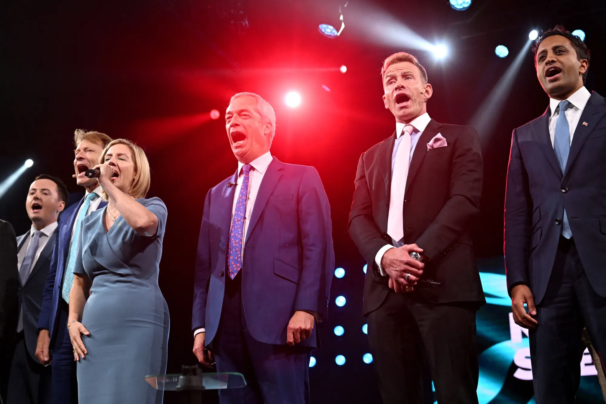 Reform’s mayor of Greater Lincolnshire, Andrea Jenkyns, left, sings the national anthem alongside Reform UK leader Nigel Farage at the party conference on Sept. 6.