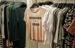 T-shirts sit on display rails inside an H&amp;M retail store in Stockholm, Sweden.
