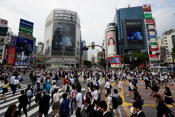 Pedestrians cross an intersection in the Shibuya district of Tokyo, Japan, on Wednesday, June 17, 2015.