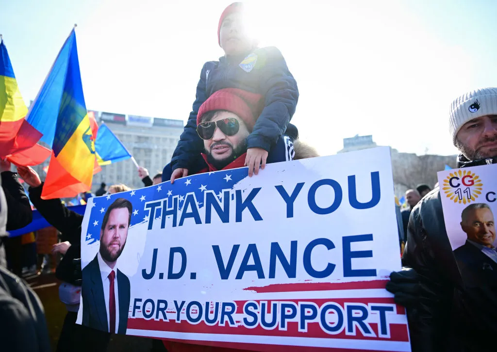 A supporter of presidential candidate Călin Georgescu holds a poster depicting US Vice President JD Vance at a&nbsp;march in Bucharest, Romania, on Feb. 22.