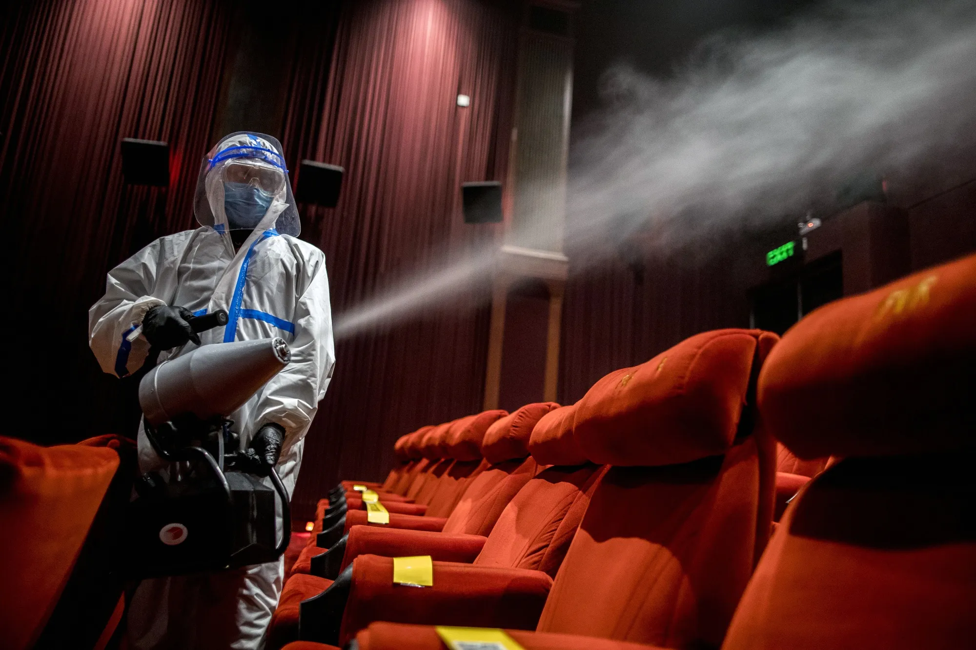 A worker sanitizes a film theater in New Delhi.