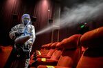 A worker sanitizes a film theater in New Delhi.