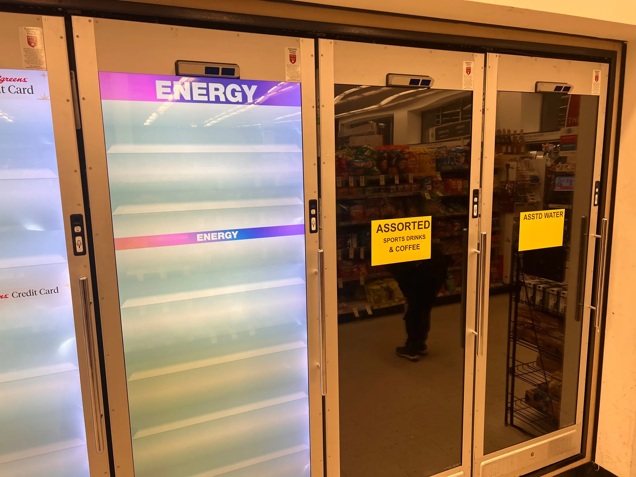 Non-functioning Cooler Screens smart doors with signs on the front the reat Assorted sports drinks & coffee and Asstd Water