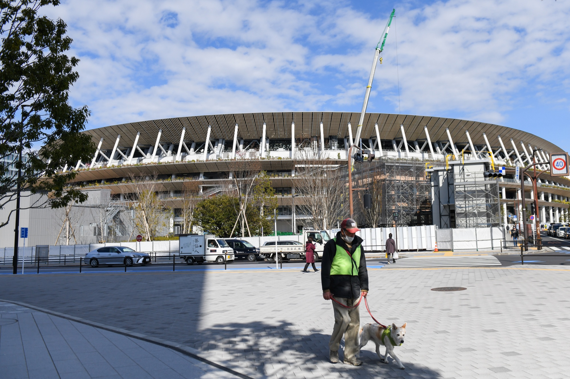 Pedestrians walk past the New National Stadium, the main venue for the 2020 Olympic and Paralympic Games, in Tokyo on Feb. 19.