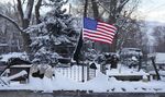An American flag flutters in the wind over over the charred remains of a home destroyed by wildfires Thursday, Jan. 6, 2022, in Superior, Colo. Colorado authorities said Thursday, that last week's wildfires caused $513 million in damage and destroyed 1,084 homes and structures.(AP Photo/David Zalubowski)