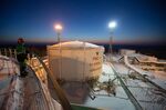 An employee watches over the oil storage facility illuminated at night in the custody transfer facility at the Salym Petroleum Development oil fields near the Bazhenov shale formation in Salym, Russia.
