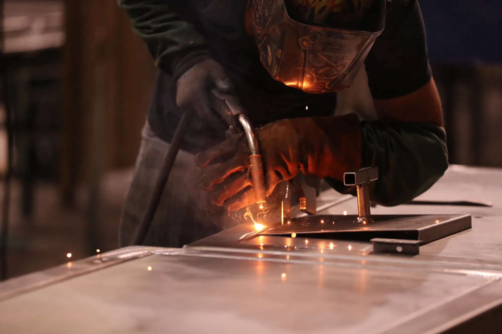 A worker welds metal.