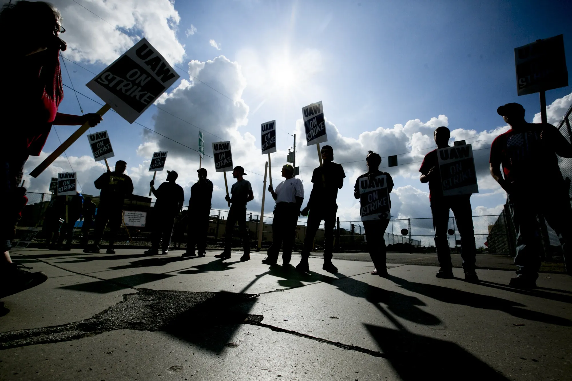 Demonstrators hold signs during a UAW strike outside the GM assembly plant in Flint, Michigan on Sept. 16.