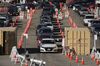 A driver receives a testing kit at a Curative Inc. Covid-19 drive-thru testing site in the parking lot of Dodger Stadium in Los Angeles, Nov. 13.