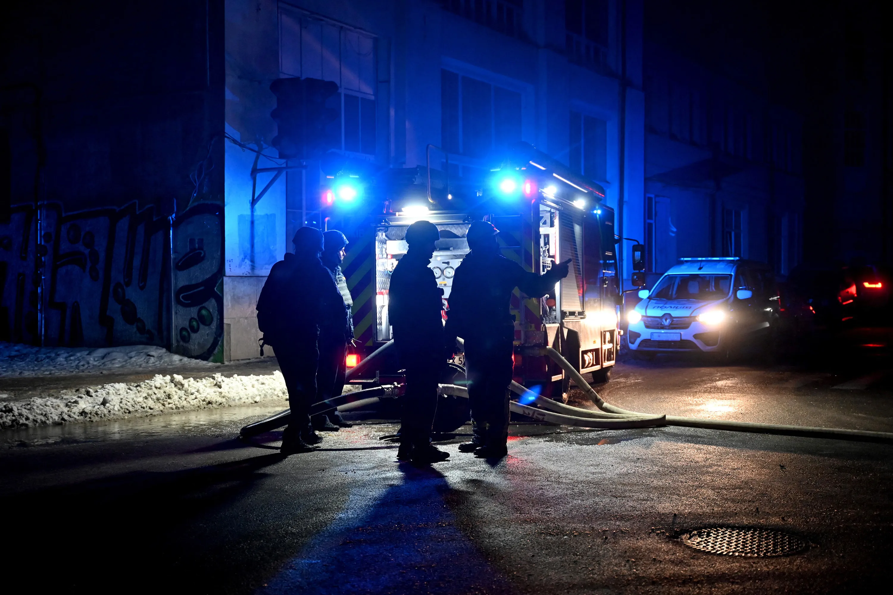 Ukrainian rescuers work at the site of a missile attack in Kharkiv late on Jan. 16.