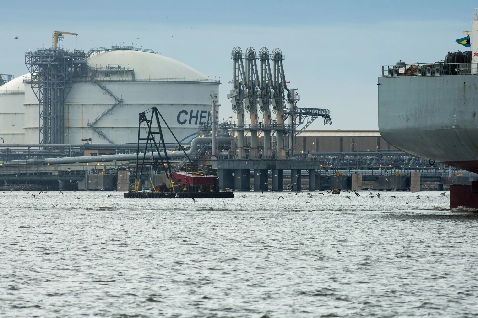 The Amazon Brilliance oil tanker, right, sails past a storage tank, left, at the Cheniere Energy Inc. liquefied natural gas (LNG) terminal in Sabine Pass, Louisiana, on Jan. 14, 2016.
