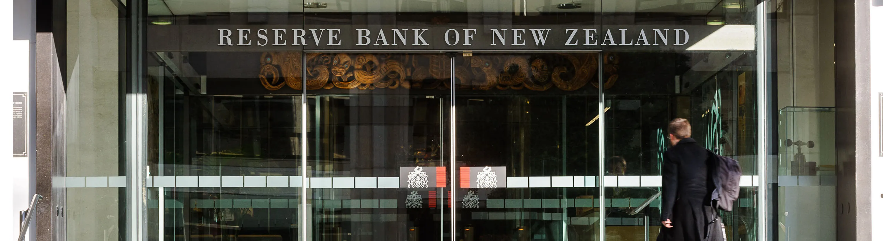 Pedestrians walk past the Reserve Bank of New Zealand headquarters in Wellington, New Zealand, on Thursday, Sept. 13, 2012.&nbsp;