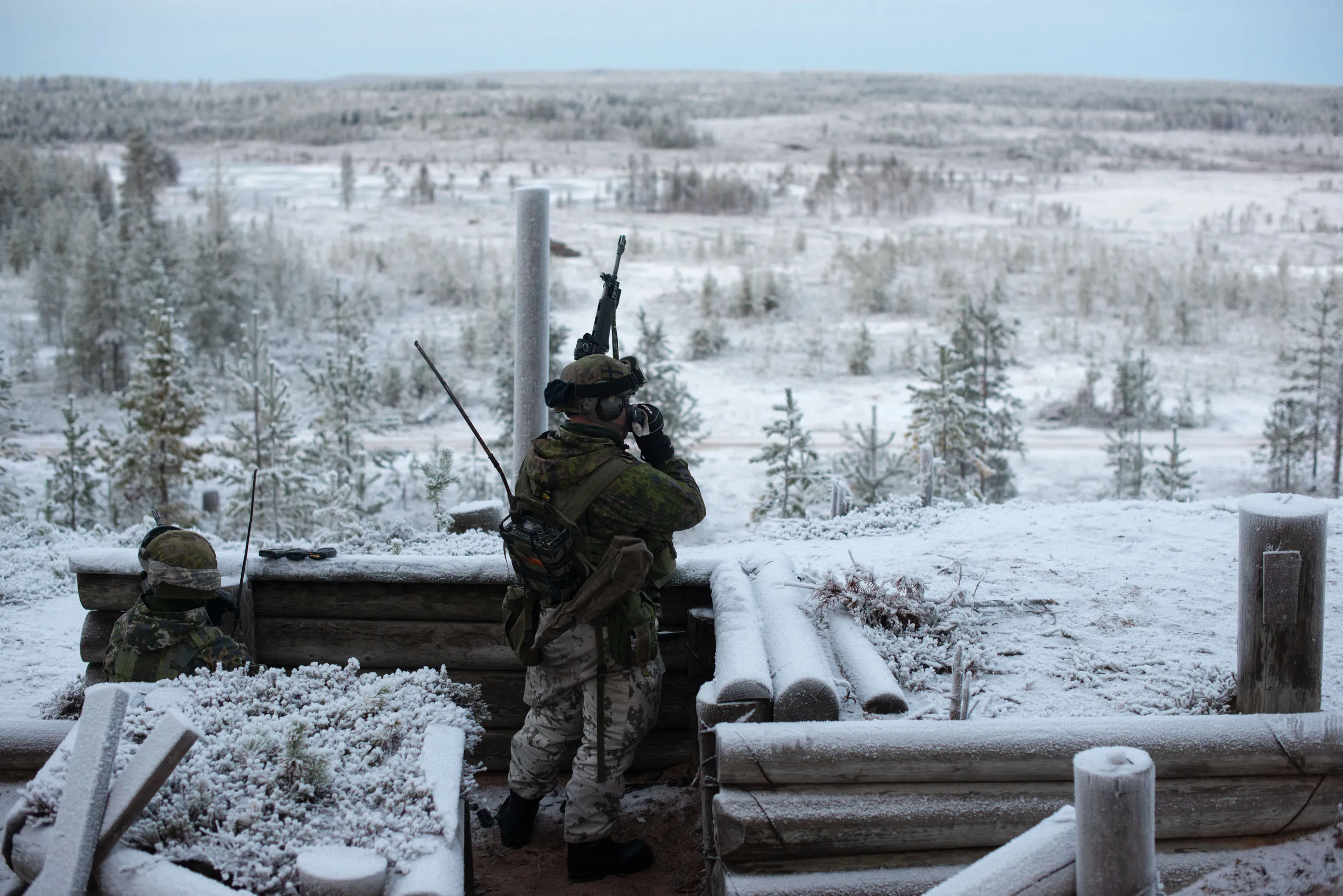 A member of the Finnish conscript, stands in front of a wooden barracks, training for anti-tank warfare in November 2025. 