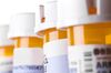 Prescription Bottles in a row on white.