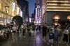 Pedestrians walk through the Nanjing Road shopping district at night in Shanghai, China, on Monday, July 29, 2019. Chinese trade negotiators will host their U.S. counterparts at a landmark of jazz-era Shanghai on the city's riverside Bund, re-opening trade talks with a marked change of atmosphere after an almost three-month hiatus.