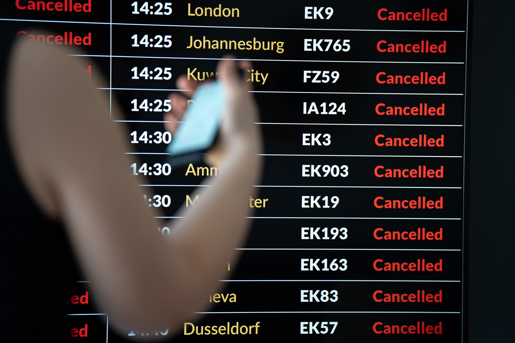 A passenger checks her flight status on an airport arrivals and departures board in Krakow, Poland, in March.