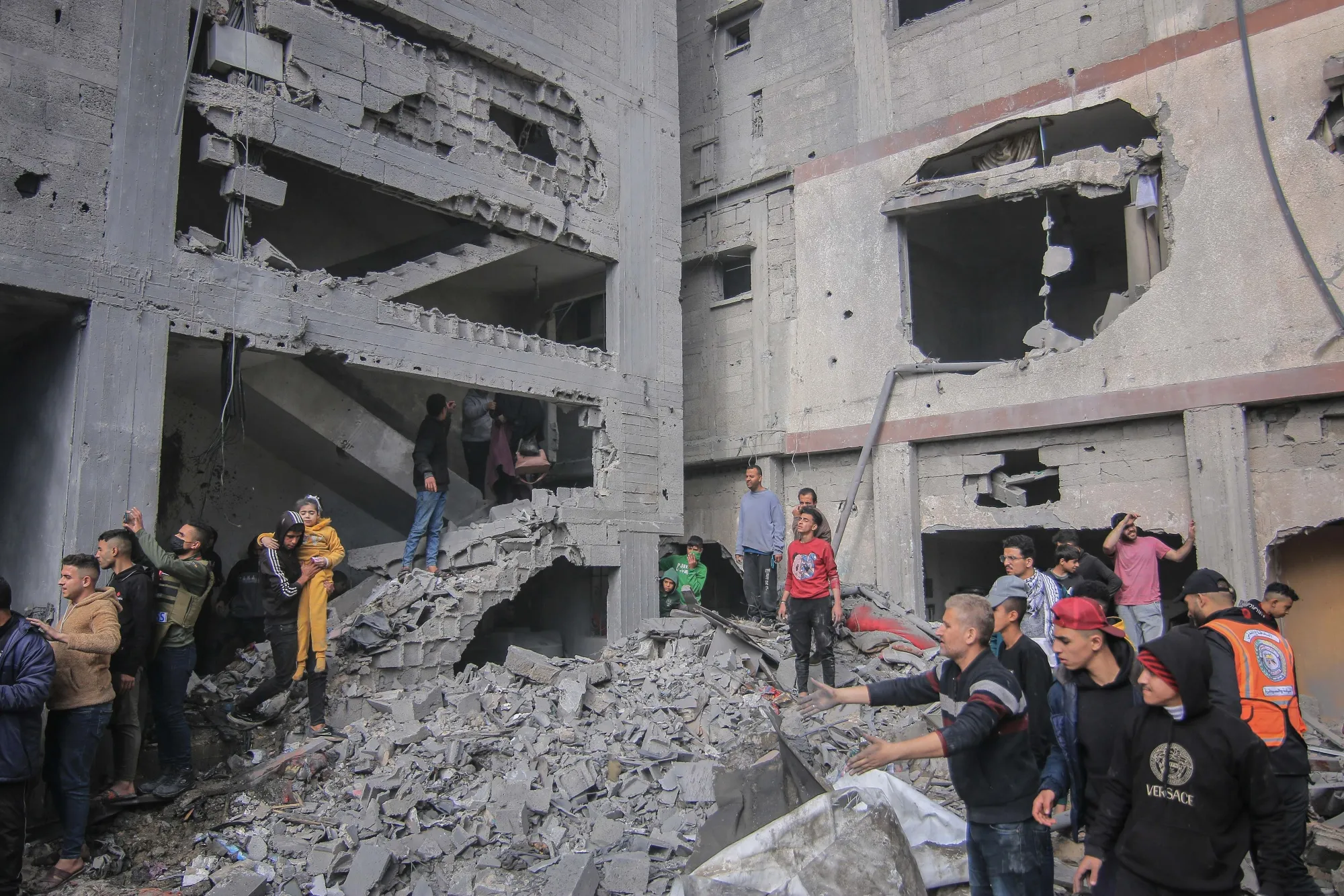Palestinians amongst the rubble of buildings hit by an Israeli airstrike in Khan Younis, southern Gaza, on Friday, Jan. 12, 2024.