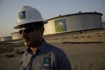 An employee visits the site of crude oil storage tanks at the Juaymah tank farm at Saudi Aramco's Ras Tanura oil refiner.