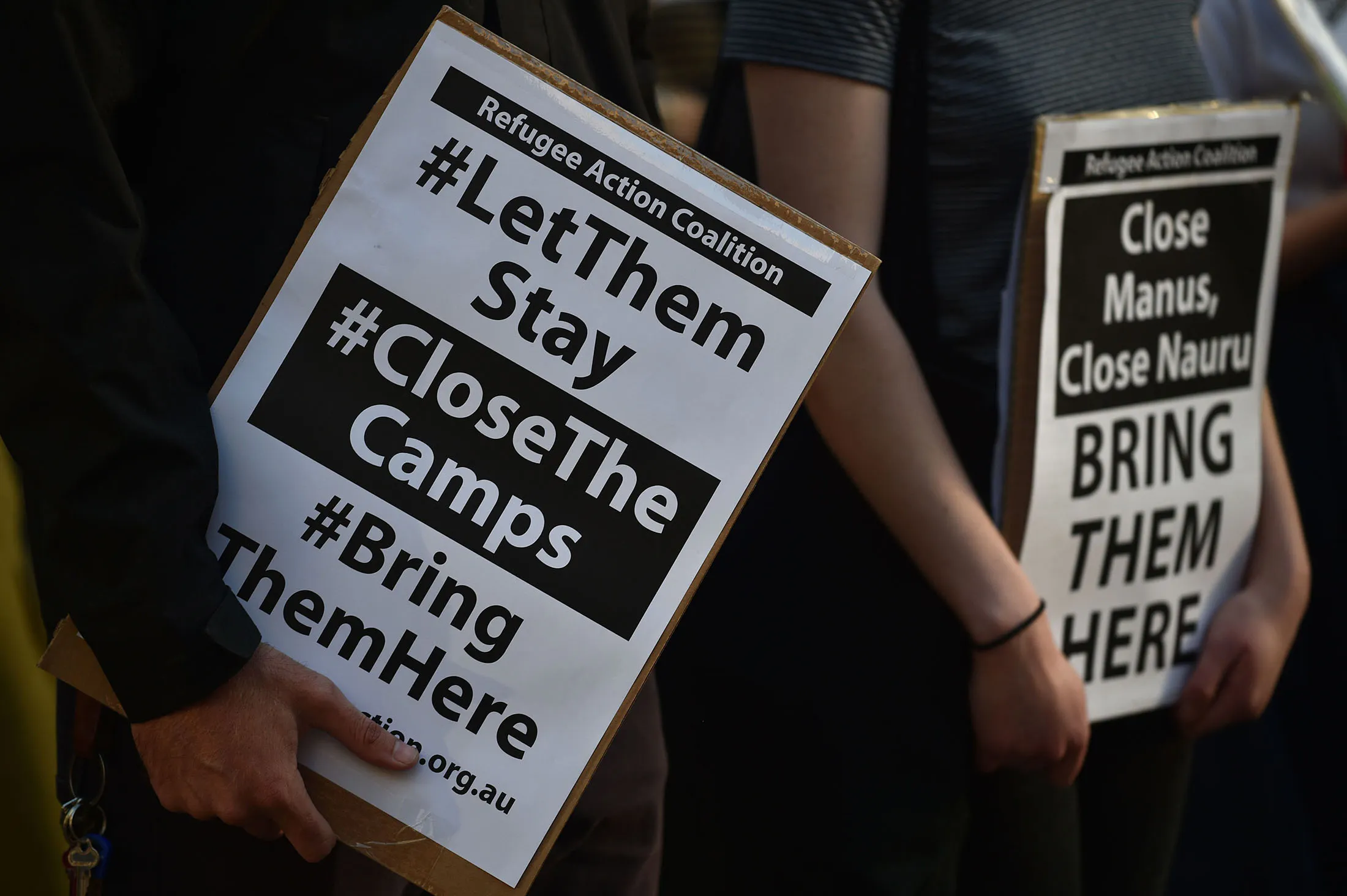 Refugee supporters hold placards as they gather in Sydney on October 5, 2016 to mark the milestone of 200 days of continuous protests in the detention camp on the Pacific island of Nauru. According to refugee support groups, asylum seekers and refugees have held a daily protest since March 20, 2016, against their incarceration on Nauru, but despite criticism of its offshore policy, Australia's conservative government has strongly defended it, saying it has halted the spate of boat arrivals, and drownings, of earlier years. / AFP / PETER PARKS (Photo credit should read PETER PARKS/AFP/Getty Images)
