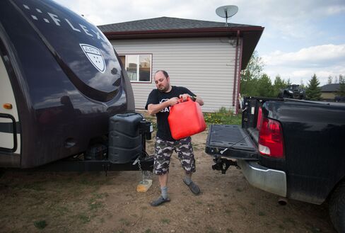 Evacuee A.J. Rosenthal carries a can of gas for his generator in Plamondon, Alberta.
