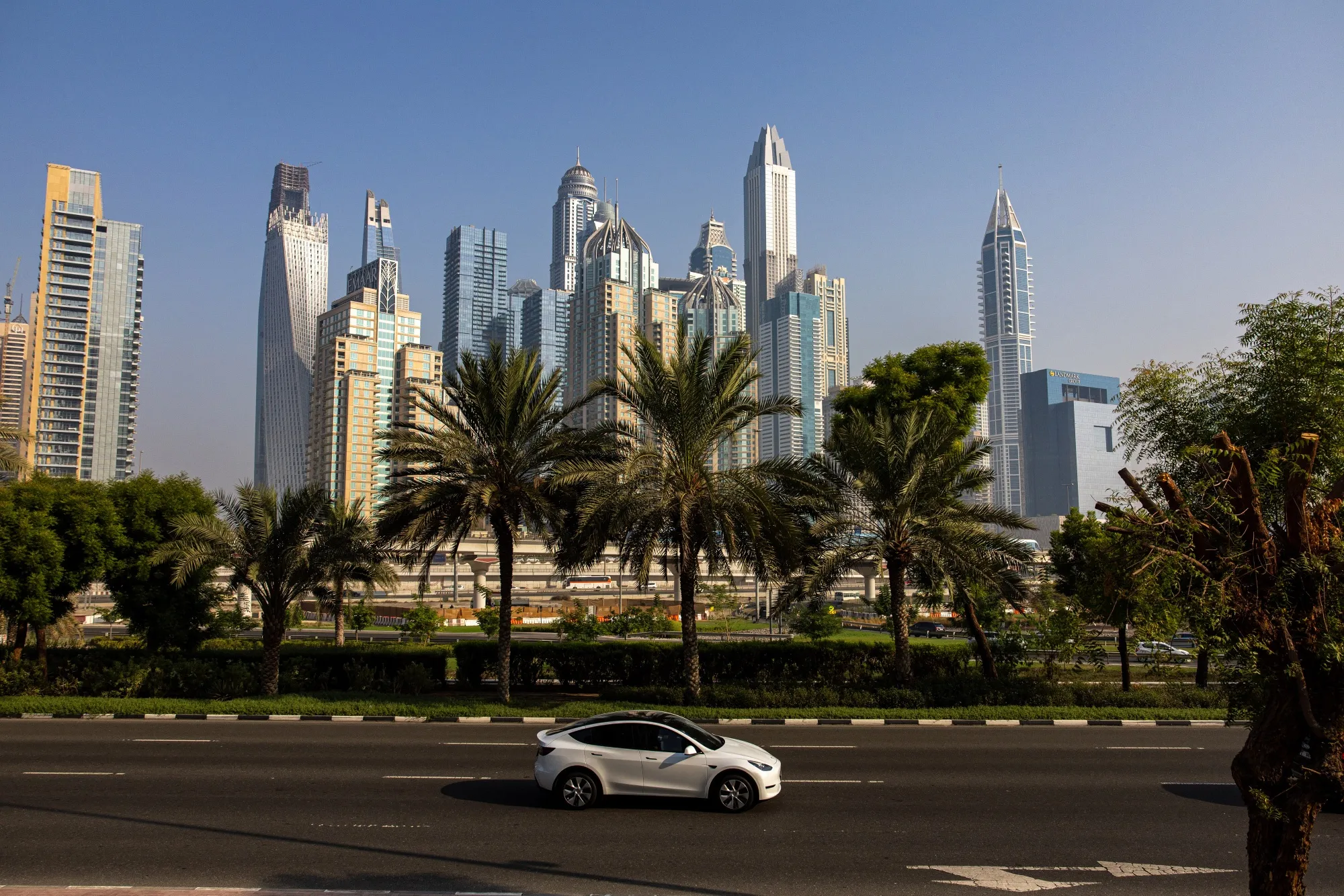A Tesla drives past skyscrapers in Dubai’s Marina district.