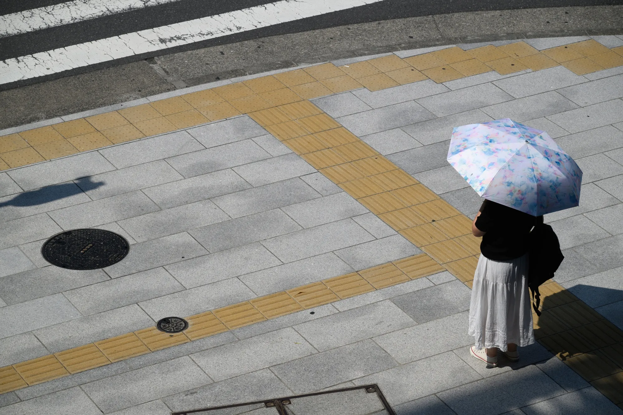 A pedestrian shelters from the sun in Tokyo.