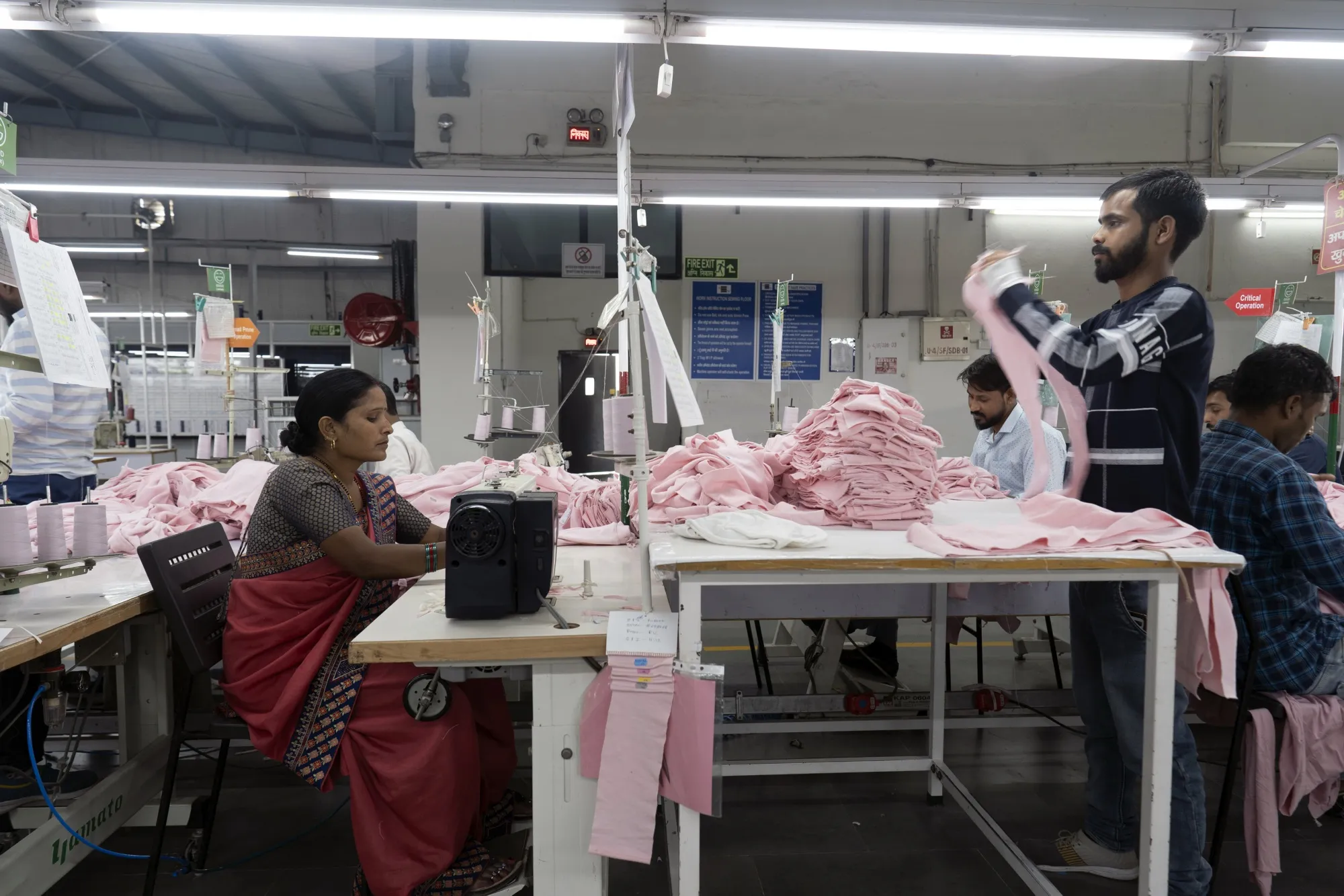 Workers on a clothing production line at a factory in Gurugram, India.