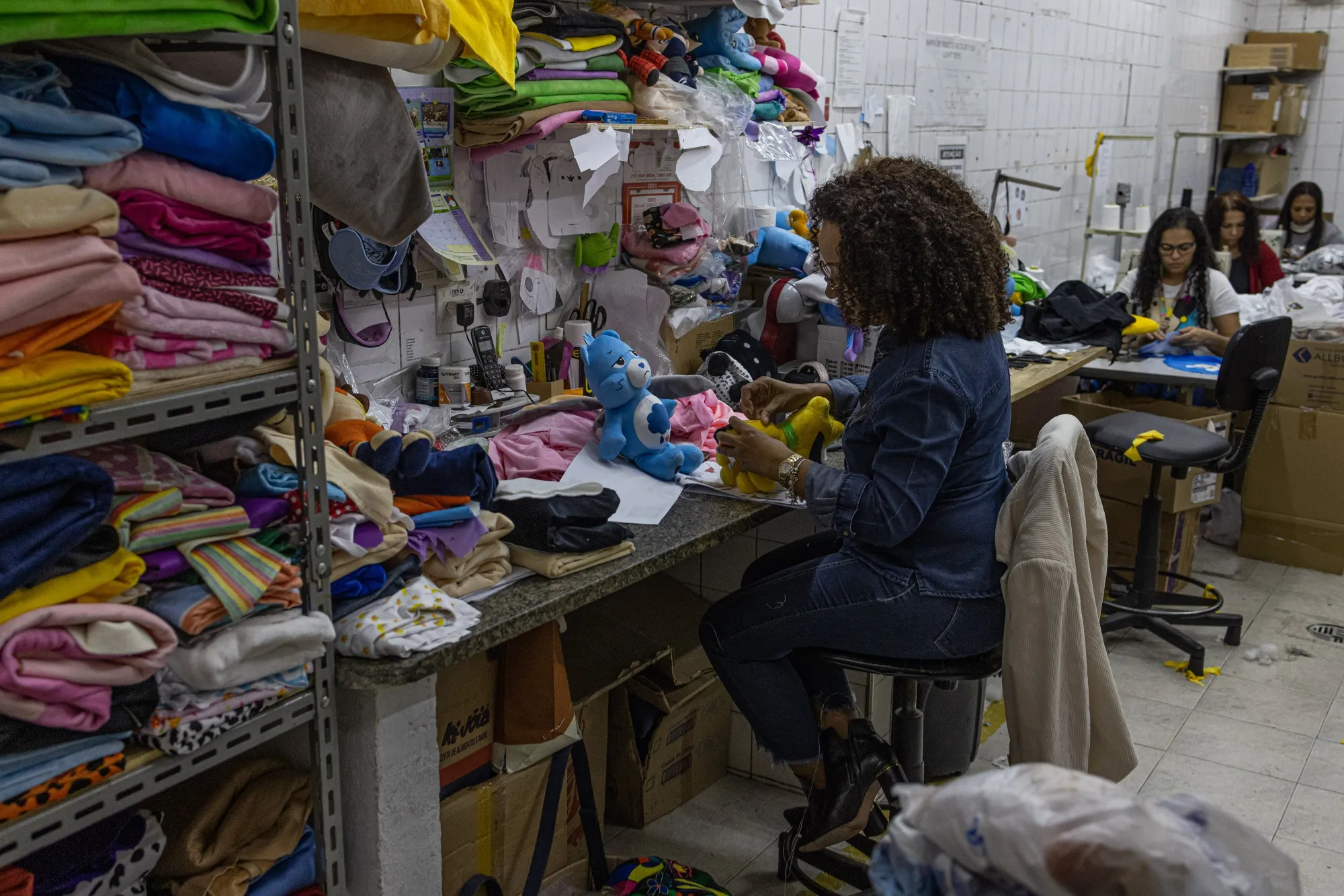 A worker creates fabric cut-outs for stuffed animals at a manufacturing facility in Sao Paulo, Brazil.