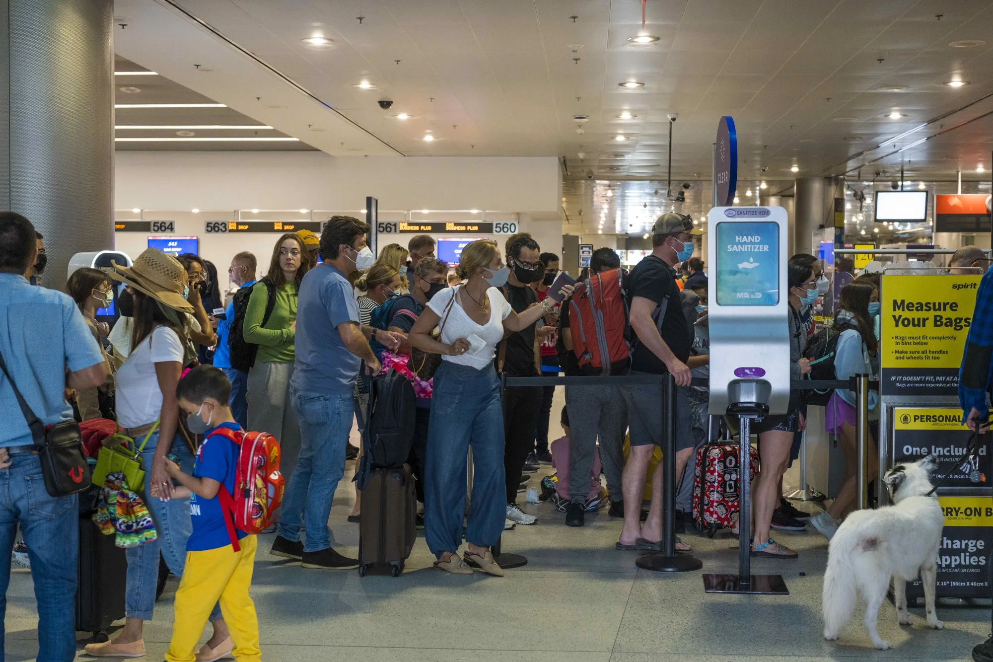 Travelers wait in a line at the departures concourse of Miami International Airport in Miami, Florida, on April 18, 2022.