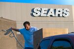 A customer secures a new washing machine purchased at a Sears store in Richmond, Calif.