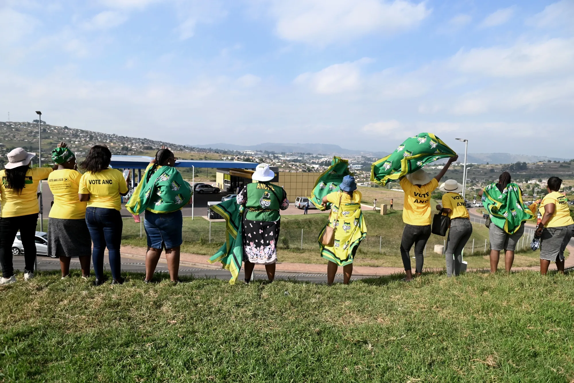 Supporters of the African National Congress wave to the motorcade of party president Cyril Ramaphosa during an election campaign event.