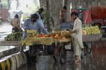 Vendors sell fruits in rain at a market in Rawalpindi, Pakistan, on&nbsp;July 29.