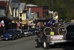 A jeep with an antique bicycle mounted drives down the Broad Street strip in Nevada City.