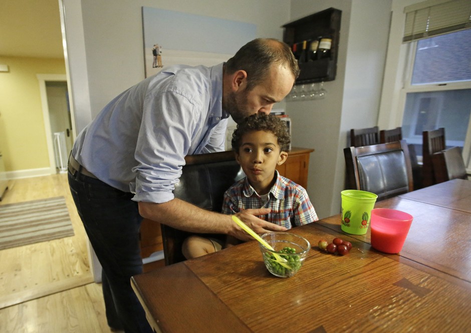 Weston Clark, kisses his son Xander, 4, while he eats at their home in Salt Lake City.