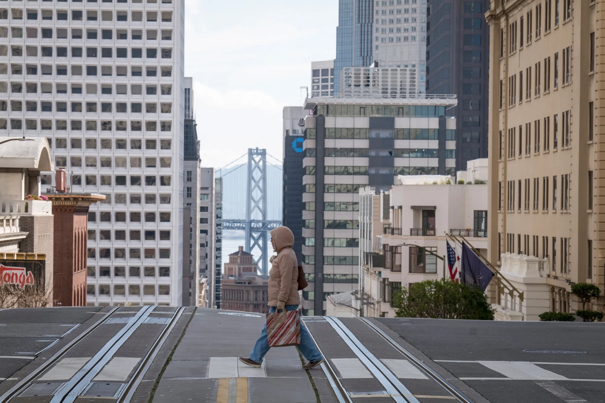 A pedestrian crosses California Street during rush hour in San Francisco on March 17.