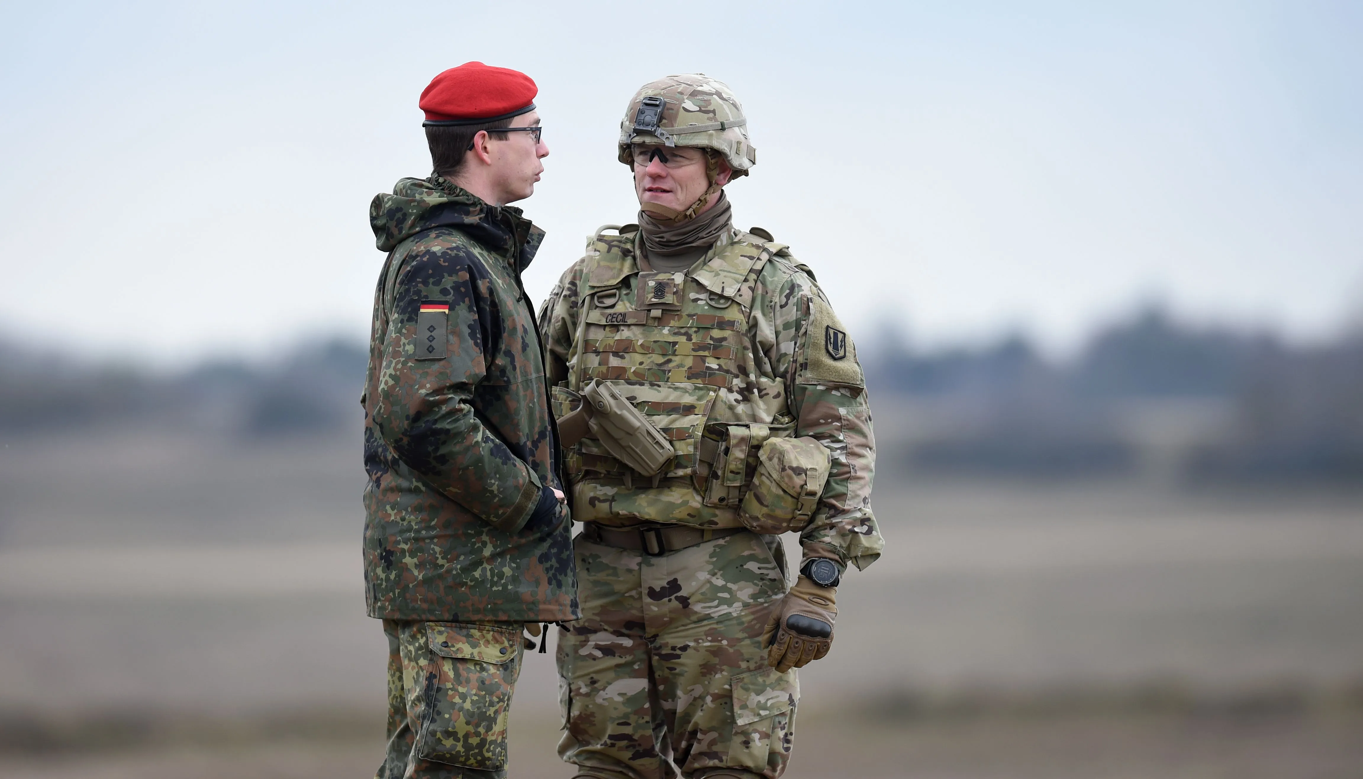 A Bundeswehr soldier, left, and an US soldier talk together during an artillery live fire event at the military training area in Grafenwoehr.