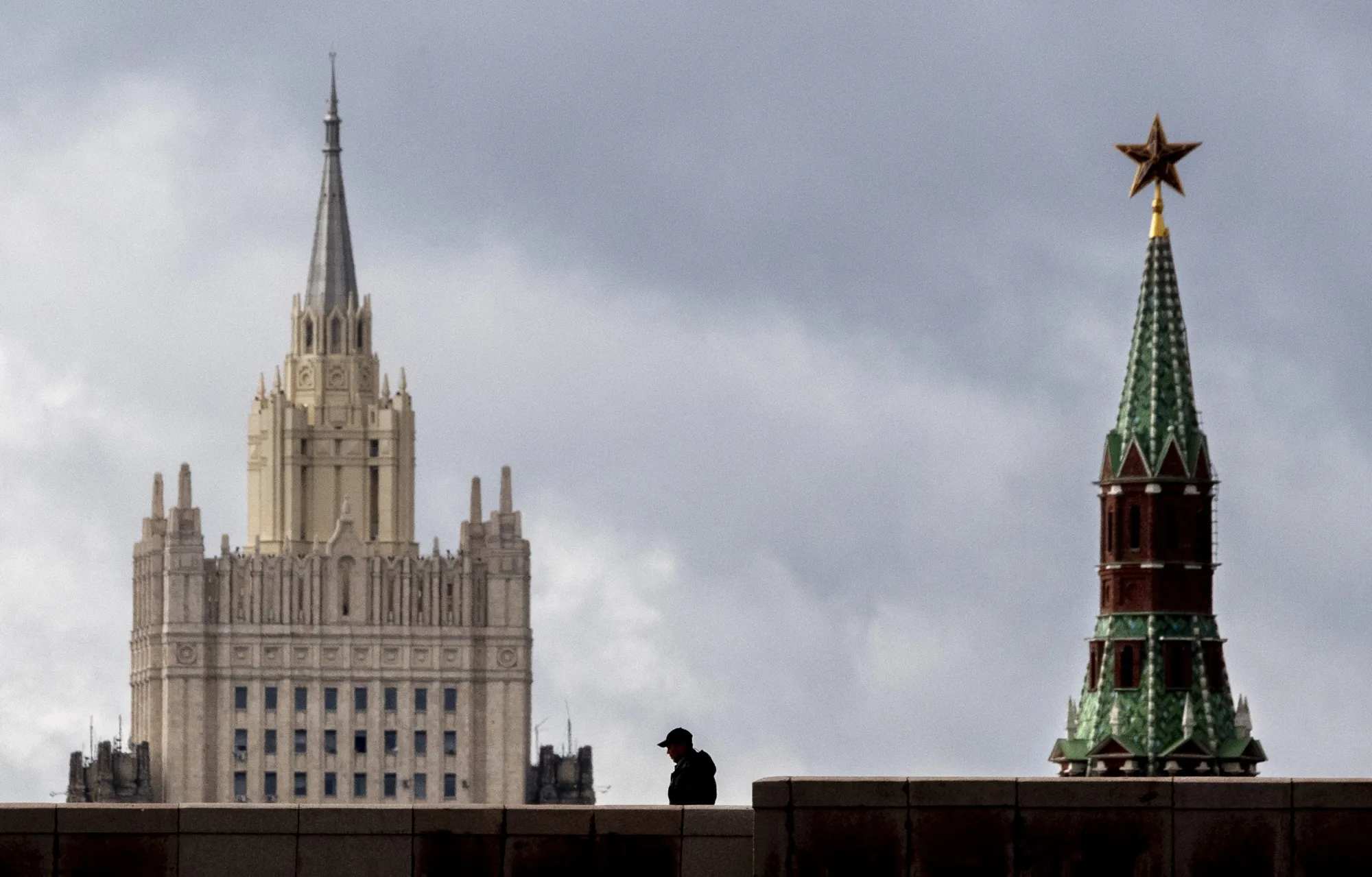 A man walks in front of a tower of the Kremlin and the Russian Foreign Ministry building in Moscow.
