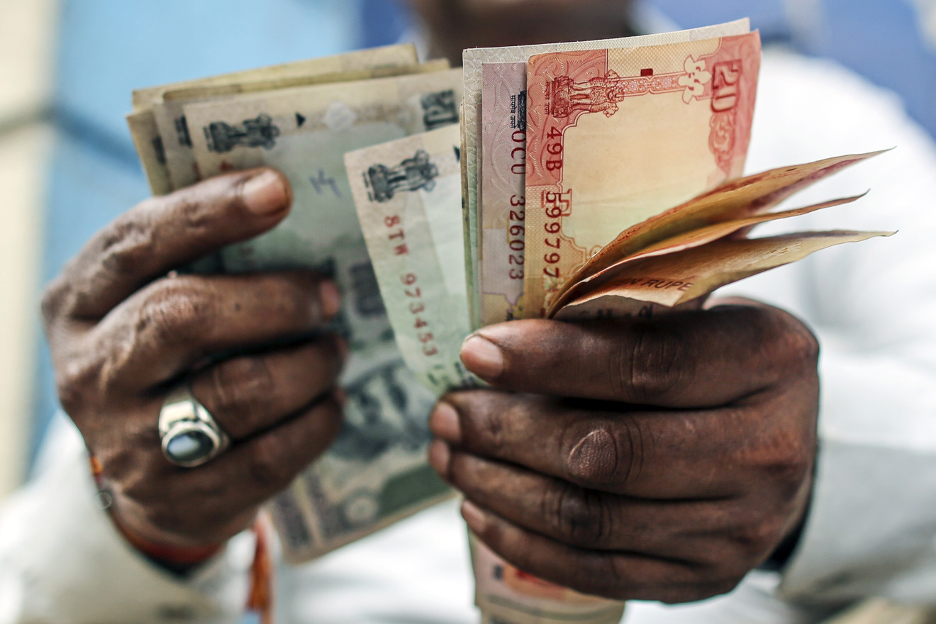 A man counts Indian rupee banknotes.