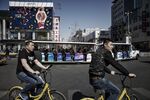 Cyclists ride Ofo Inc. bikes through downtown Beijing
