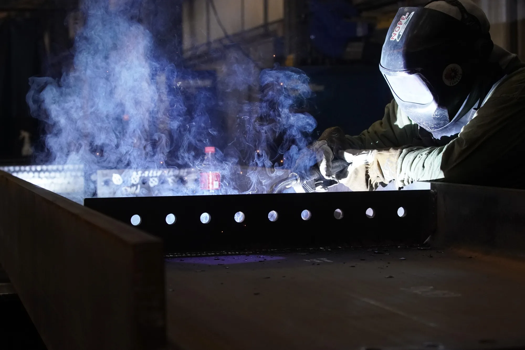 A worker welds a structural steel beam during production at the SME Steel Contractors facility in West Jordan, Utah.
