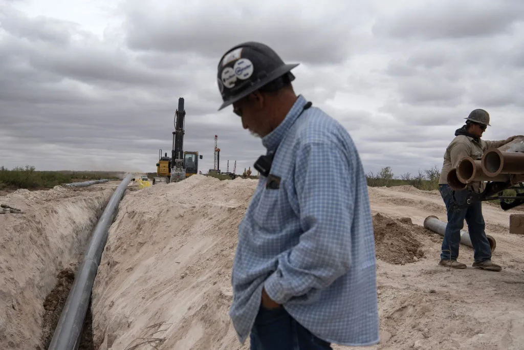 Workers with S&amp;J Contractors lay a pipeline in Lea County, New Mexico.