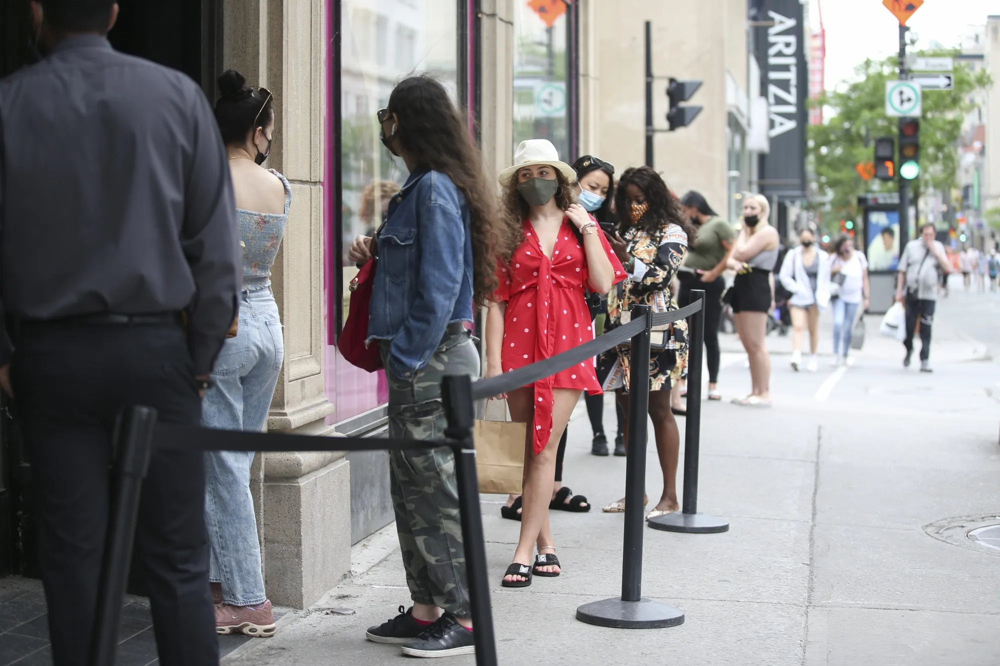Shoppers wait in line outside of a downtown Montreal retail store on June 5.