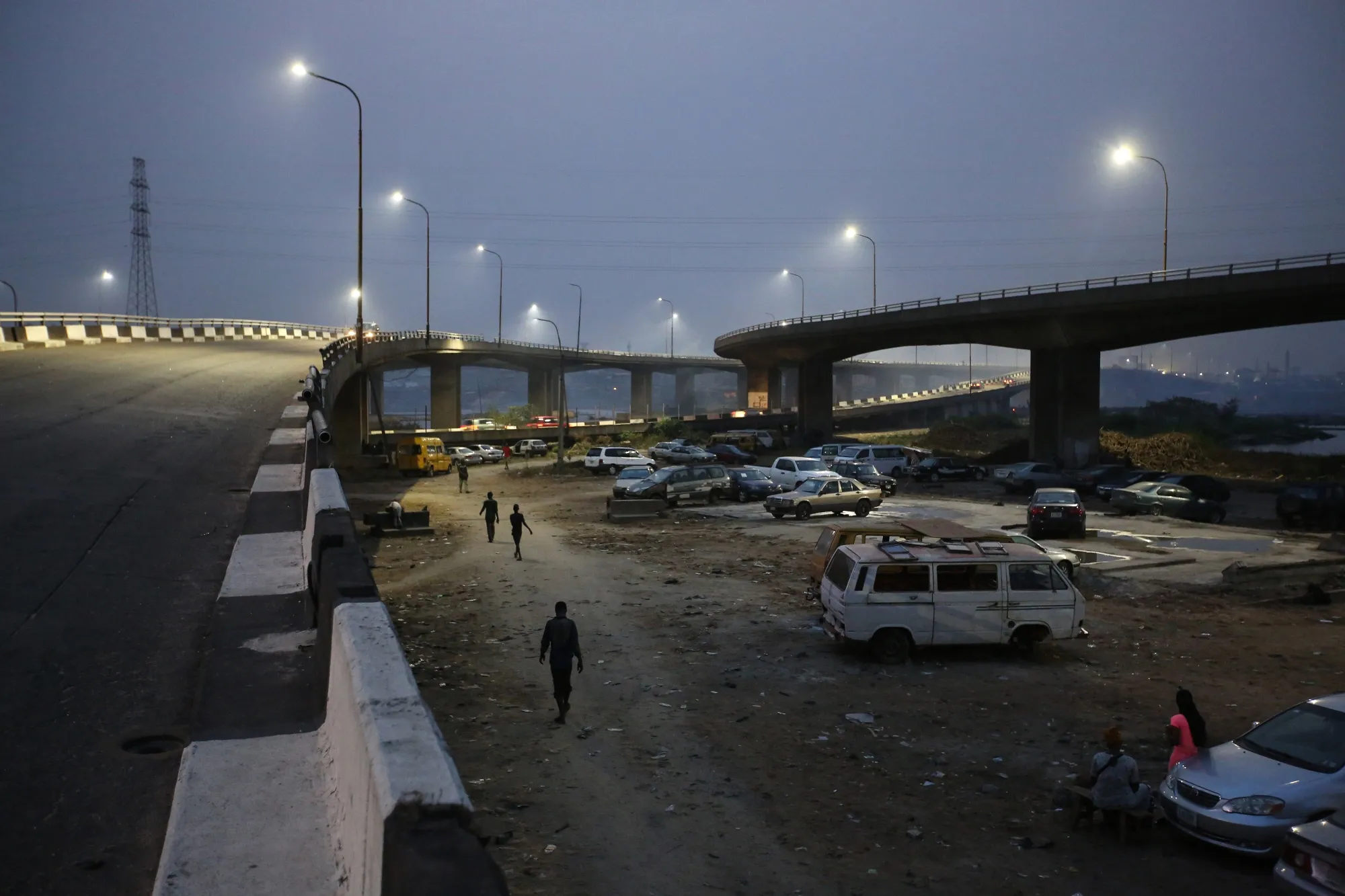 People walk under a bridge as night falls in Lagos on Feb. 28.