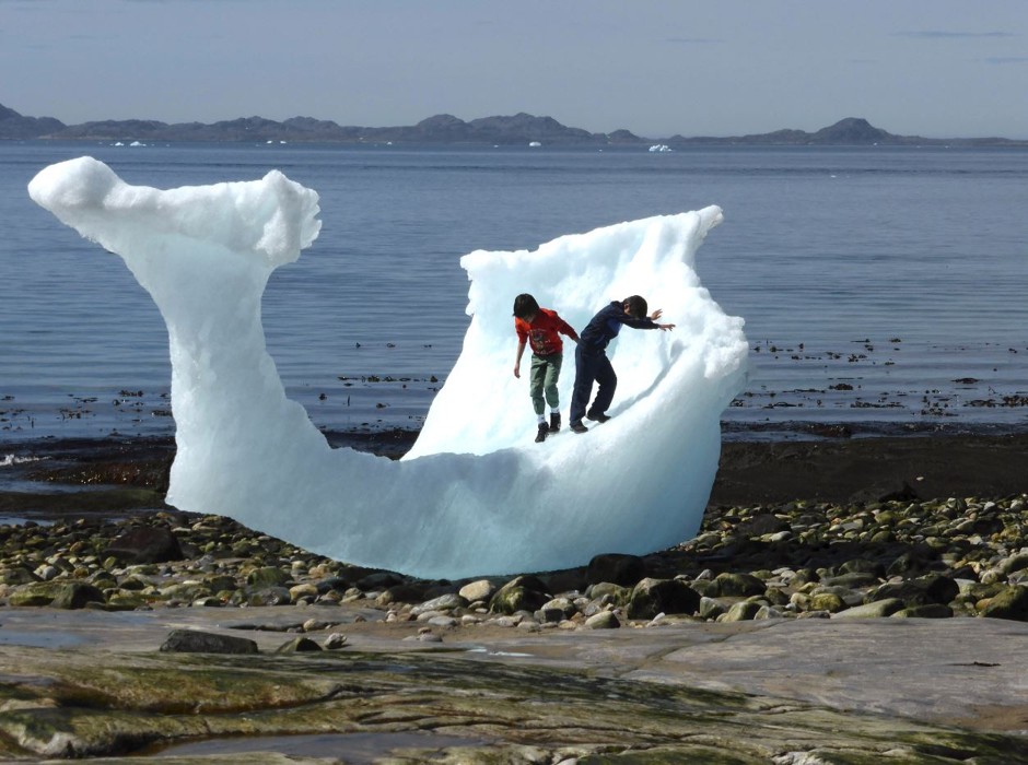 Children play on a melting iceberg in Nuuk, Greenland.