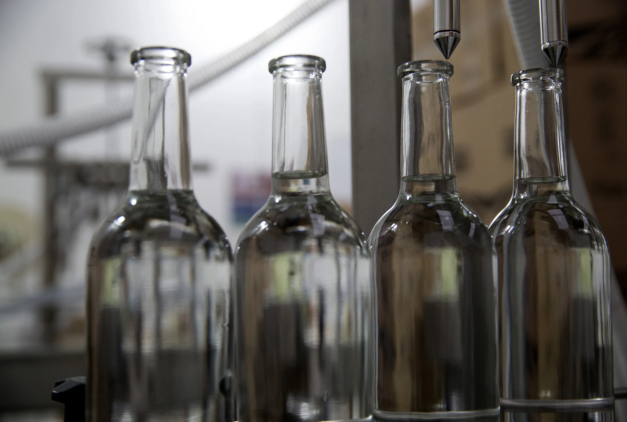 Bottles stand under the filling machine at the Mezcal Union production facility.
