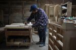A factory worker sands down a piece of a wooden chair at a furniture shop in Auburn, Kentucky.
