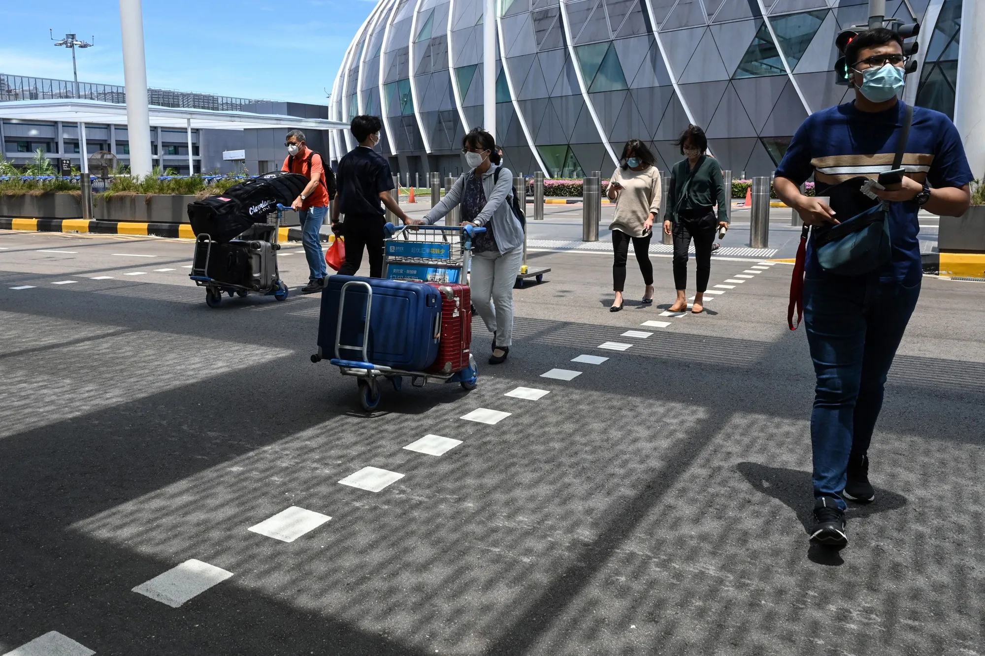 Travelers arrive at the departure hall of Changi International Airport in Singapore on Aug. 19