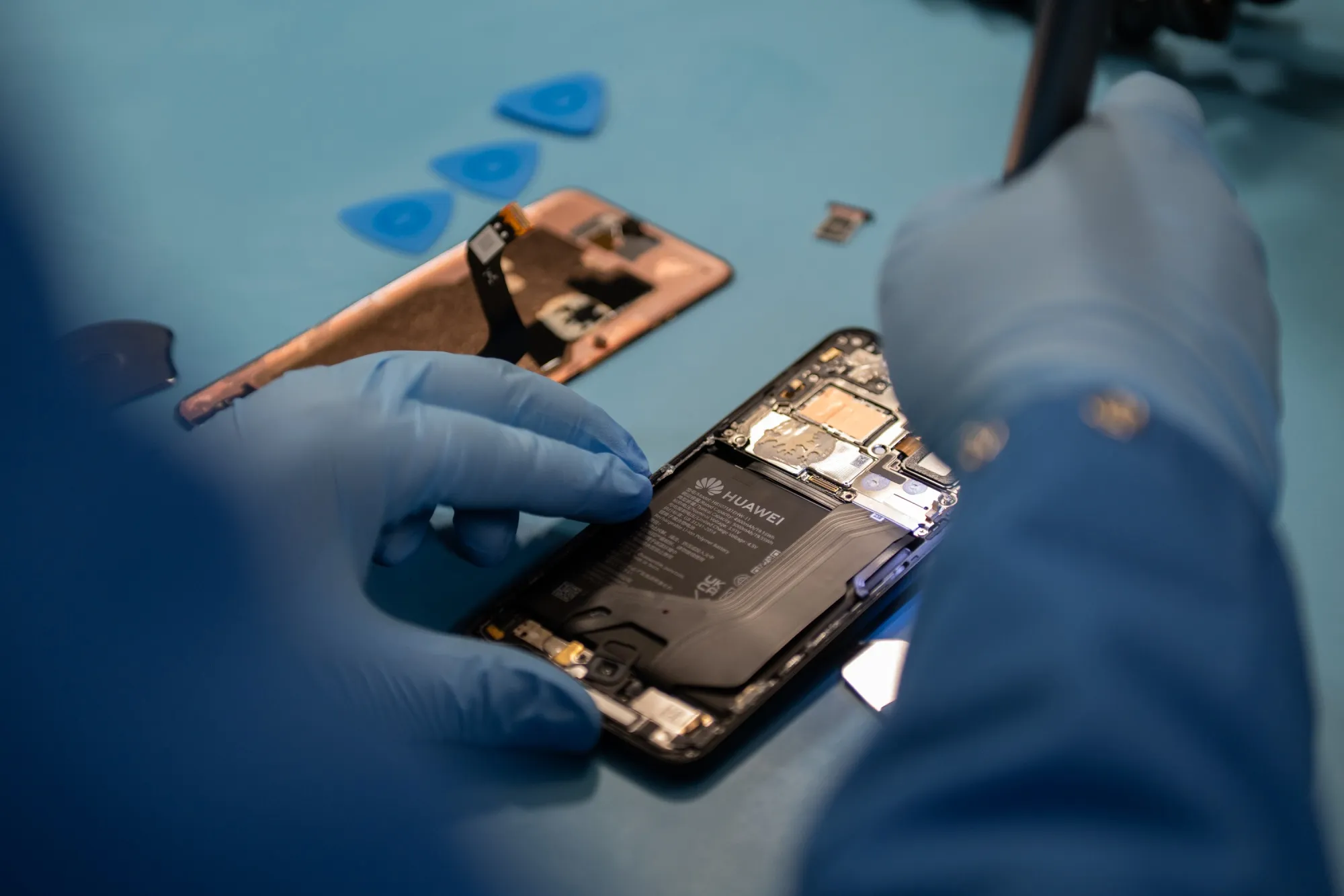 A specialist disassembles a Huawei Mate 60 Pro smartphone.