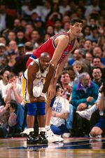 Gheorghe Muresan stands behind Tim Hardaway during a game played circa 1995 in Oakland, California.