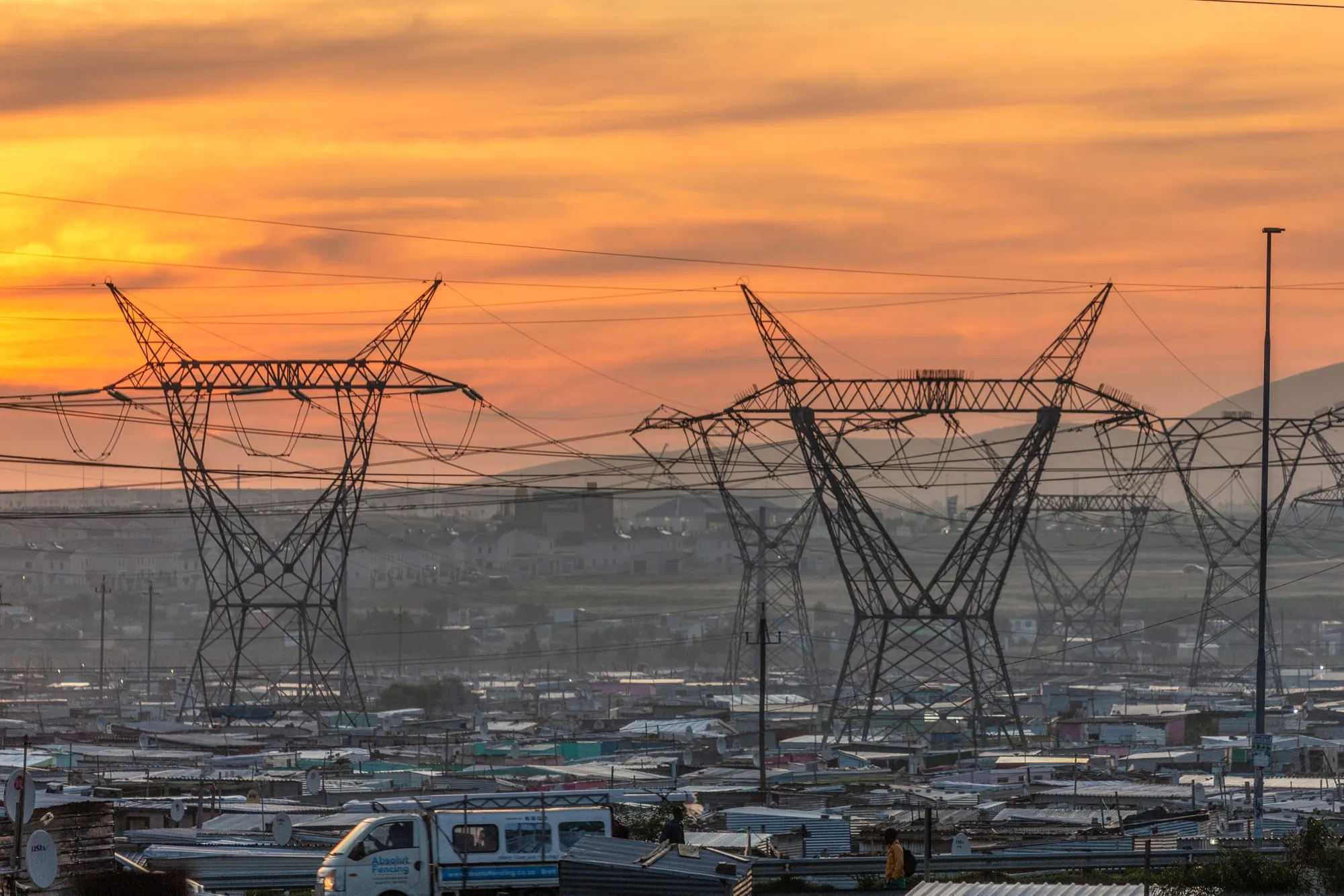 Eectricity transmission towers above an&nbsp;informal settlement area of Cape Town.&nbsp;&nbsp;